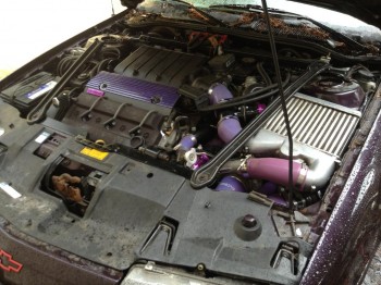 A divider plate (not installed in this pic) separates the intercooler/intake area from the turbocharger and the rest of the engine bay. This keeps the air fresh and cool here. The hood-scoop has a 'vented' area behind the scoop to allow the hot air a place to rise out, so it does good providing both in and out breathing for the intercooler.